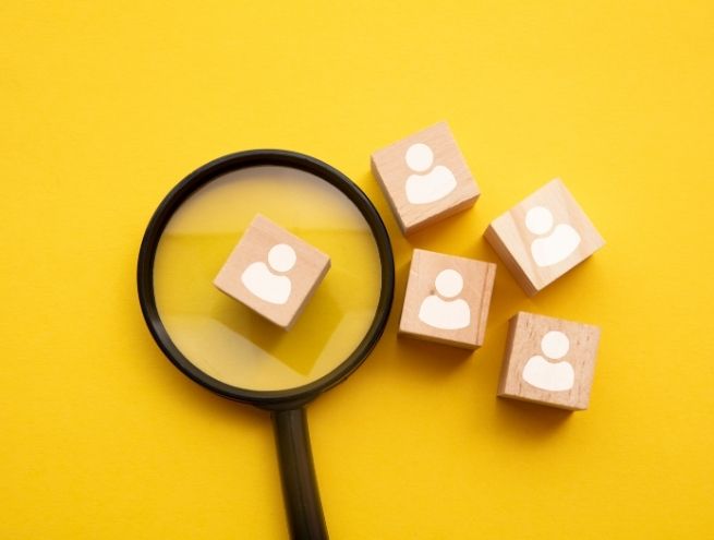 Loupe mettant en valeur des icônes de profils illustrant le recrutement et les opportunités d'emploi