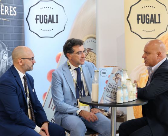 Professionnels en réunion sur un stand d’exposition pour échanger autour de produits alimentaires et d’opportunités de partenariat