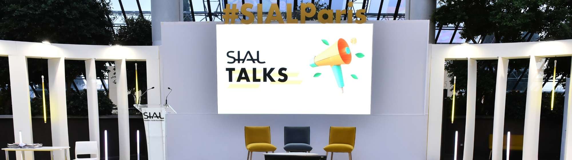 Scène SIAL Talks au salon SIAL Paris avec pupitre, écran géant et fauteuils dans un espace événementiel moderne.