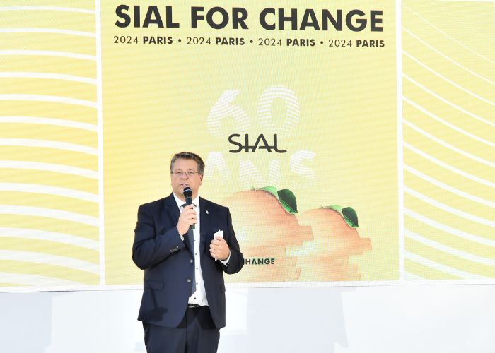 Intervenant en costume tenant un micro et faisant un discours sur scène au SIAL for Change 2024 à Paris