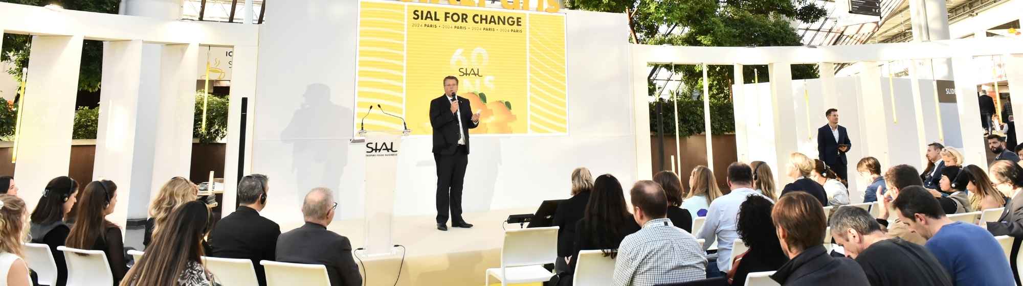 Conference with speaker on stage addressing a seated audience at SIAL for Change 2024 in Paris