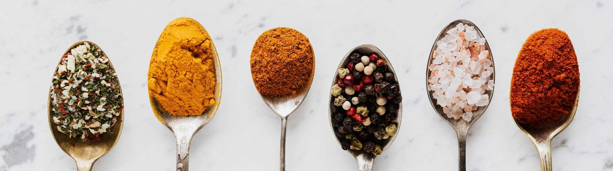 Cuillères contenant différents ingrédients alimentaires en poudre.