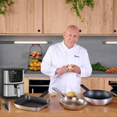 Un chef en train de préparer des pommes de terre avec une friteuse sans huile et des ustensiles de cuisine.
