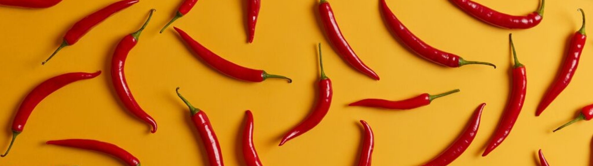 Bannière montrant des piments rouges disposés sur un fond coloré, créant un impact visuel fort