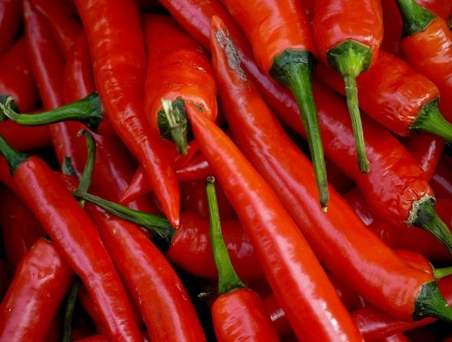 Piments rouges frais sur un fond noir.