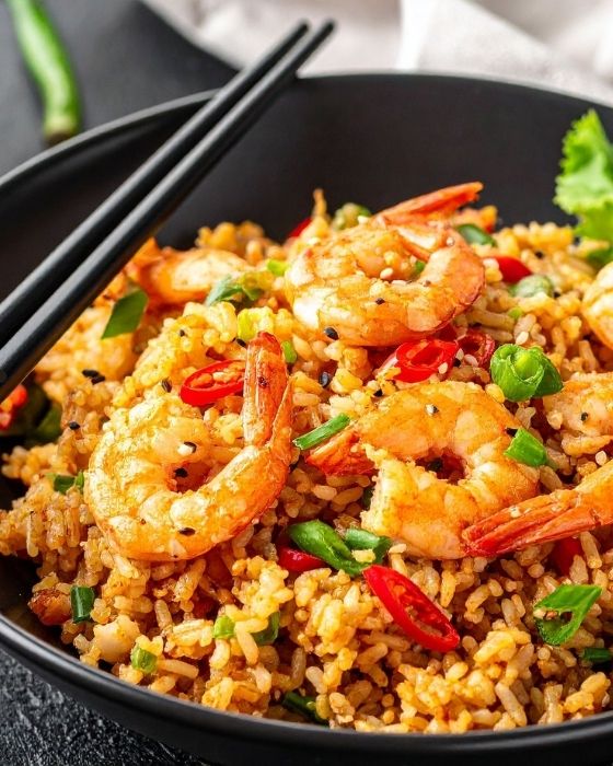 Plate of shrimp rice with fresh red chilies.