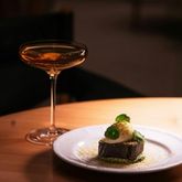 Verre de vin servi lors d’un repas gastronomique dans un cadre raffiné