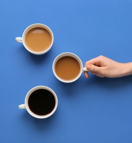 Three coffee cups with hand on blue background