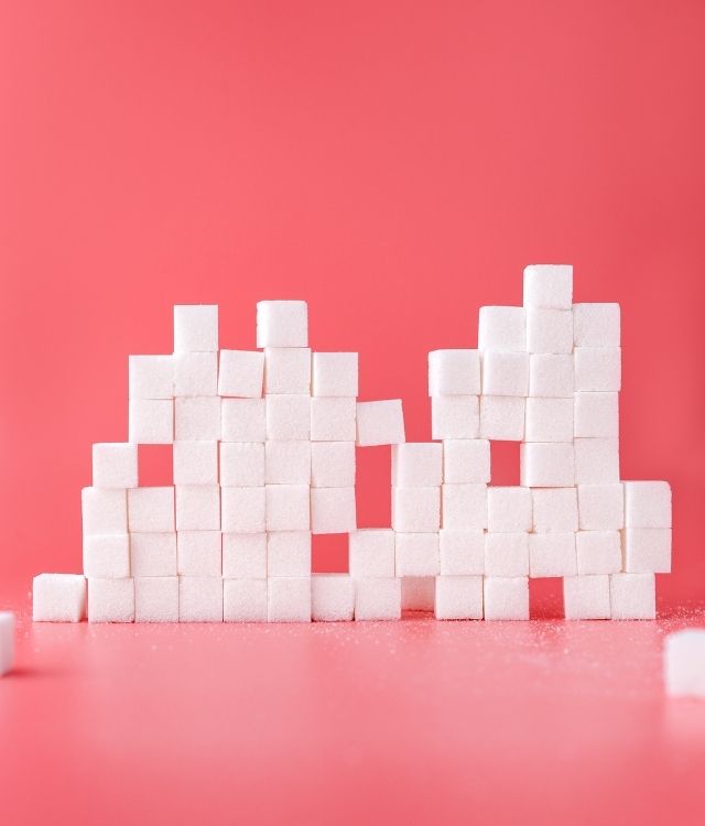 White sugar cubes on pink background