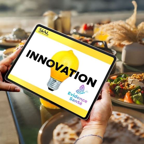 Tablet displaying the word "INNOVATION" and a lemon lightbulb, held in hands with a food background.