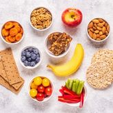 Assortment of healthy snacks including fruits, vegetables, and grains.