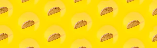 Repeating pattern of bread slices on yellow background, concept of cereals and grain-based food