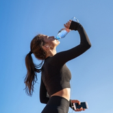 Woman drinking water outdoors