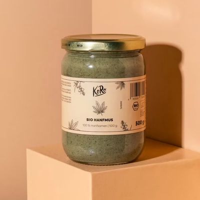 Jar of hemp-based plant spread displayed on a minimalist beige background