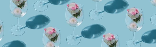 Row of glasses with pink drinks on pastel blue background