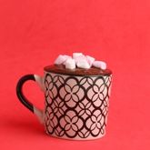 Hot drink cup with marshmallows on red background