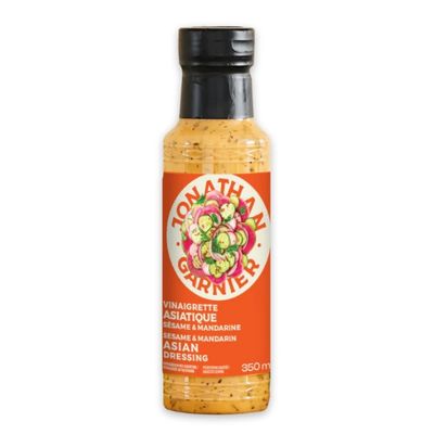 Bouteille de vinaigrette asiatique au sésame et à la mandarine sur fond blanc