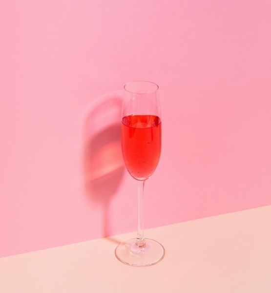 Rosé champagne flute on minimalist pink background