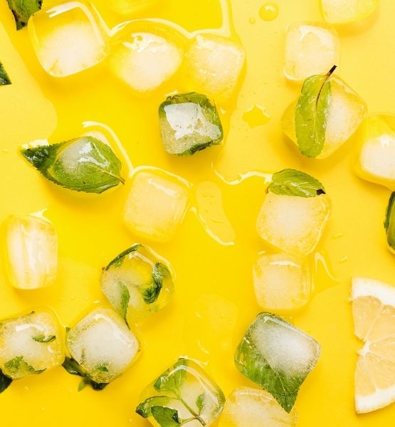 Lemon and mint ice cubes on bright yellow background