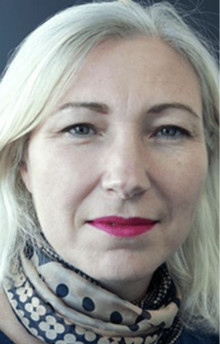 Portrait rapproché d’une personne blonde portant un foulard à pois, avec rouge à lèvres rose.