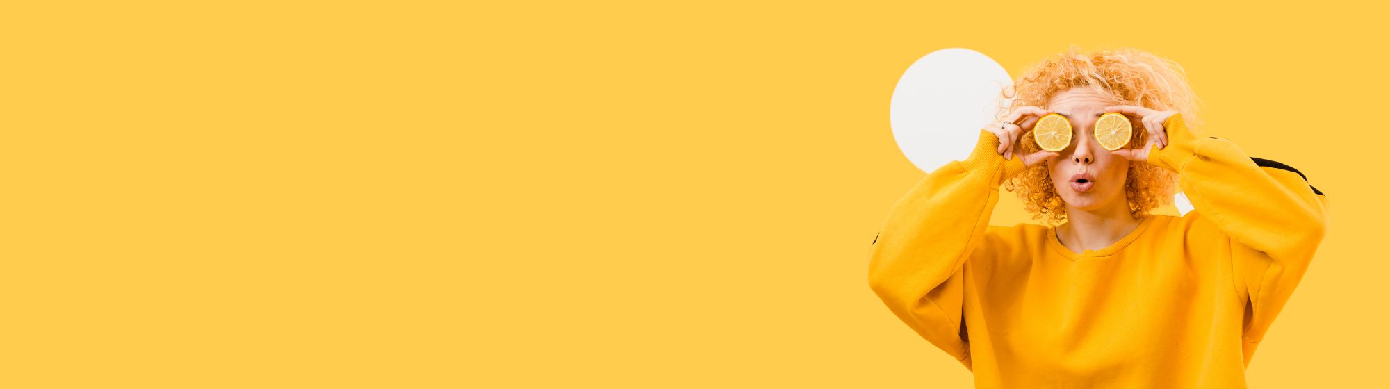 Yellow banner with a person in a yellow sweatshirt holding lemon slices over their eyes, positioned on the right.