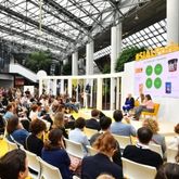 Conference at SIAL with a group of people listening to a speaker on stage in front of a large audience.