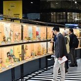 Visiteurs de SIAL explorant une exposition de produits alimentaires sur des étagères dans une ambiance dynamique.